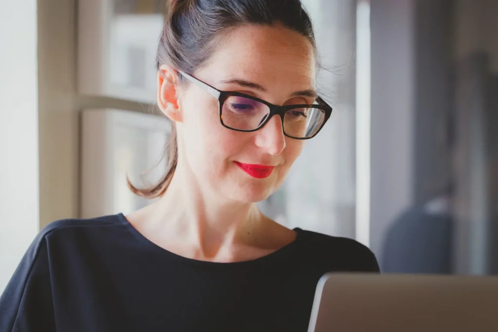 Woman working on laptop and smiling confidently | Computappoint